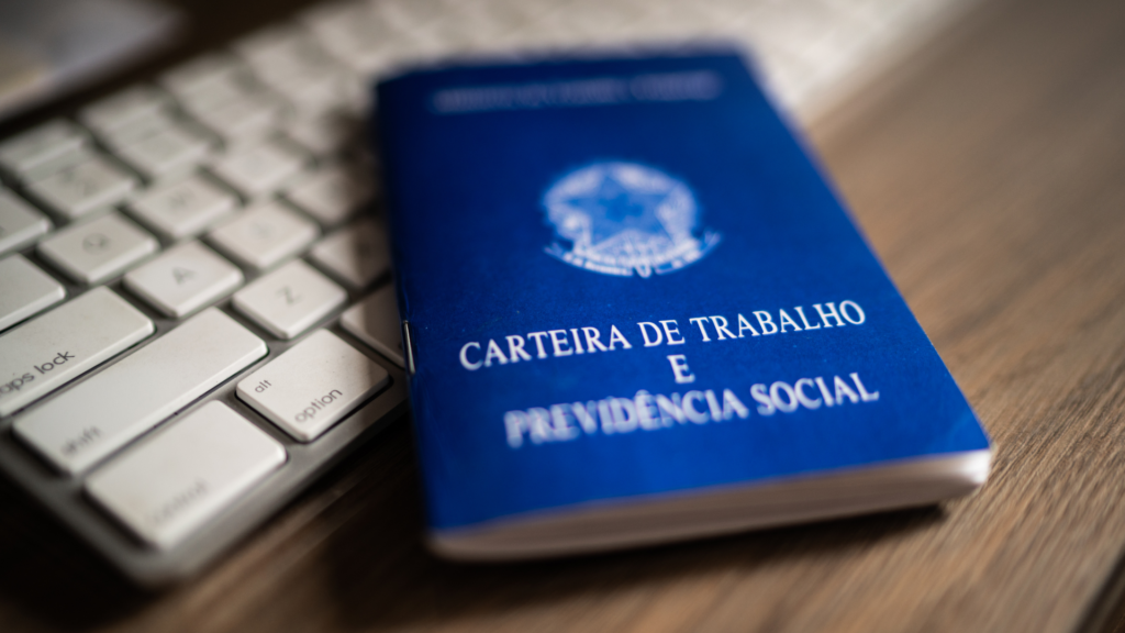 Carteira de trabalho sobre teclado, ilustrando tema sobre notificação do Ministério Público do Trabalho