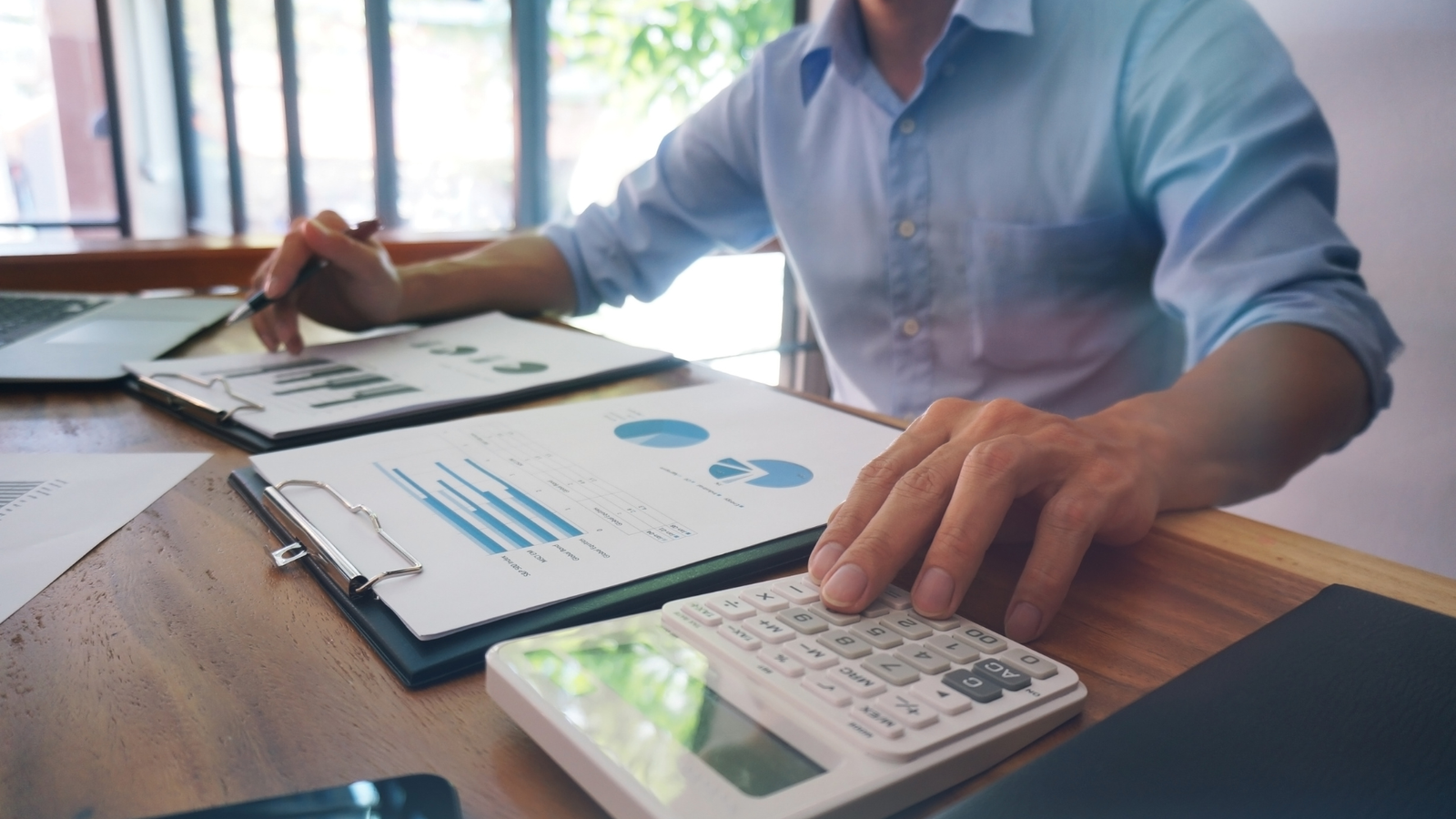 Empresário revisando relatórios financeiros, representando dúvidas sobre benefícios fiscais e enquadramento tributário.